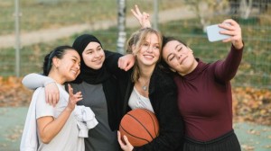 Vier Mädchen machen ein Selfie mit Basketball